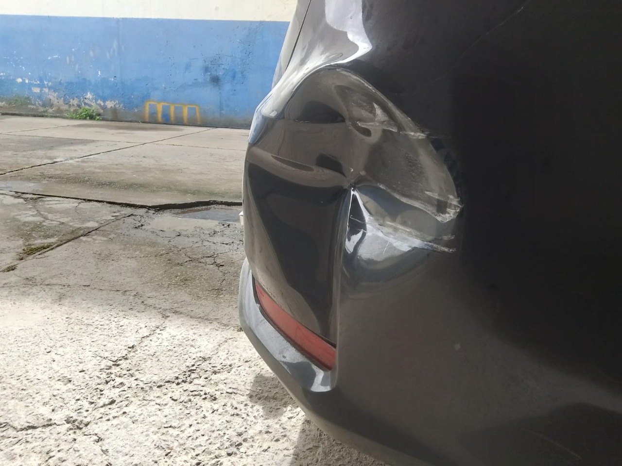 Amassado na lateral traseira de veículo escuro